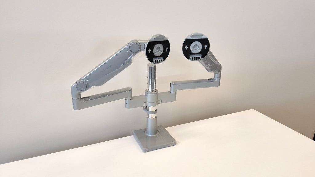 Humanscale dual monitor arm in silver, mounted on desk